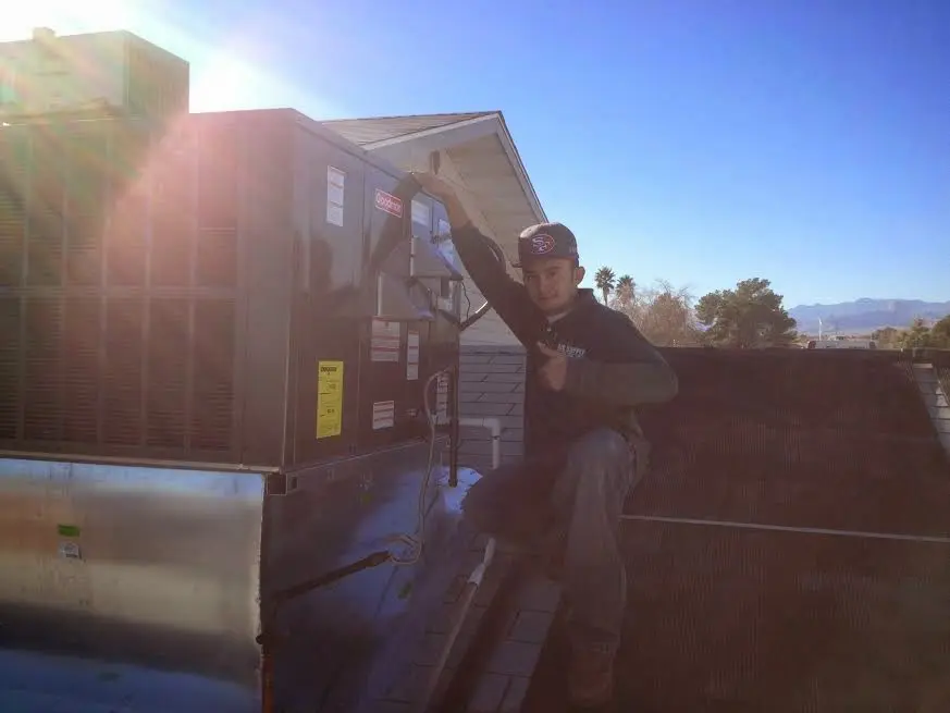HVAC technician performing AC Tune-Up on a rooftop unit in Iron Mountain